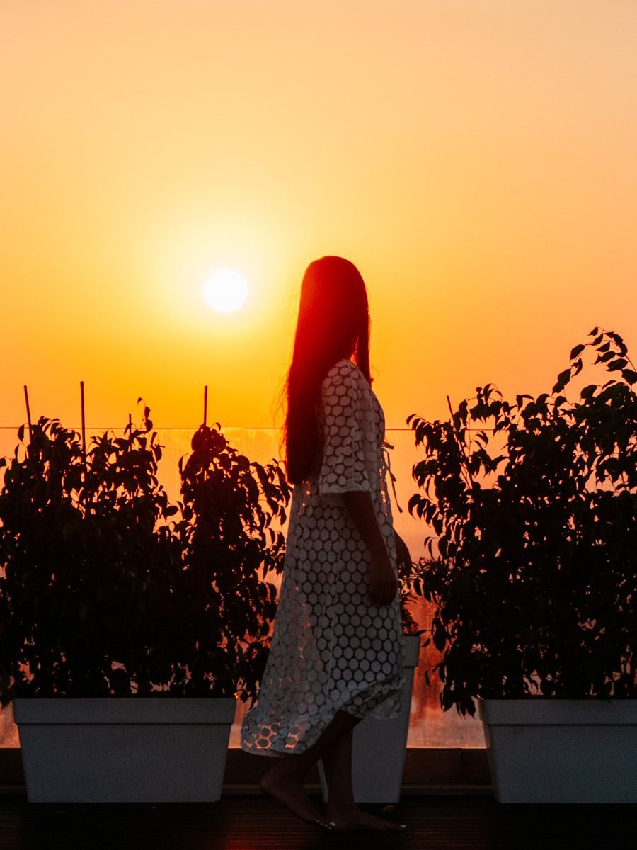 Frau am Pool im Sonnenuntergang
